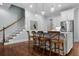 Kitchen island features white cabinets, wood barstools, copper faucet, stainless appliances, and wood floors at 2792 River Vista Way, Mount Pleasant, SC 29466