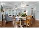 Living room area with bright natural light, wood floors, white sofas, dining table, and decorative lighting at 2792 River Vista Way, Mount Pleasant, SC 29466