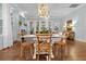 Living room and dining room area with wood floors, white sofas, dining table, and decorative lighting at 2792 River Vista Way, Mount Pleasant, SC 29466