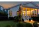 Inviting rear exterior view showcasing a screened porch with a fan, lit by warm lights at dusk at 2792 River Vista Way, Mount Pleasant, SC 29466