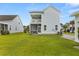 Expansive backyard featuring a well-manicured lawn and a charming two-story home with dual porches at 2881 Rutherford Way, Charleston, SC 29414