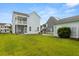 Spacious backyard offering lush green grass and a view of the house, garage, and neighboring homes at 2881 Rutherford Way, Charleston, SC 29414