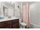 Bright bathroom with a modern vanity, sink, toilet, and a peach shower curtain at 2881 Rutherford Way, Charleston, SC 29414