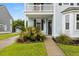 Inviting two-story home featuring a manicured front yard, mature palm trees, and classic architectural details at 2881 Rutherford Way, Charleston, SC 29414