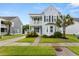Inviting two-story home featuring a manicured front yard, mature palm trees, and classic architectural details at 2881 Rutherford Way, Charleston, SC 29414