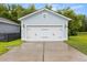 Well-maintained detached garage with a white door and dark hardware, set against a backdrop of green lawn at 2881 Rutherford Way, Charleston, SC 29414