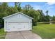 Detached garage with a white door complemented by a lush green lawn and a tranquil pond backdrop at 2881 Rutherford Way, Charleston, SC 29414