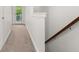 Bright hallway featuring carpet, a half wall, and a staircase with a wooden handrail at 2881 Rutherford Way, Charleston, SC 29414