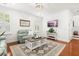 Bright living room with hardwood floors, comfortable seating, neutral walls, and plantation shutters for privacy at 2881 Rutherford Way, Charleston, SC 29414