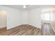 A clean bedroom with wood-look floors and a ceiling fan is next to a hallway with a window at 2947 Sweetleaf Ln, Johns Island, SC 29455
