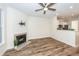 Comfortable living room with hardwood floors, fireplace, wall-mount TV, and views into the adjacent kitchen area at 2947 Sweetleaf Ln, Johns Island, SC 29455