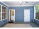Covered back porch with blue siding, two doorways, and an outdoor rug to provide a relaxing outdoor space at 2947 Sweetleaf Ln, Johns Island, SC 29455