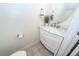 Stylish powder room with marble countertop vanity, modern fixtures, decorative mirror, and neutral tile flooring at 2947 Sweetleaf Ln, Johns Island, SC 29455