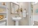 Well-lit bathroom with a pedestal sink, decorative mirror, and modern fixtures at 2961 Waterleaf Rd, Johns Island, SC 29455