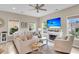 Bright living room with hardwood floors, ceiling fan, fireplace, and large windows at 2961 Waterleaf Rd, Johns Island, SC 29455