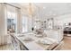 Airy dining area featuring large windows, a statement chandelier, and views of the living area at 308 Archar St, Summerville, SC 29486