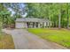 Charming single-story home with a well-manicured lawn and a long driveway leading to an attached garage at 309 Kingbird Rd, Ladson, SC 29456