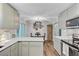 Bright kitchen featuring white cabinets, sleek countertops, wood floors, and stainless steel appliances at 309 Kingbird Rd, Ladson, SC 29456