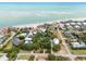 Aerial view of a coastal community with beach access and a mix of colorful and traditional homes amidst lush greenery at 3109 Ion Ave, Sullivans Island, SC 29482