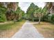 Large, grassy backyard with walking path and trees in the background at 3109 Ion Ave, Sullivans Island, SC 29482