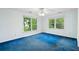 A bright bedroom with blue carpet, two windows with tree views, and a ceiling fan at 3109 Ion Ave, Sullivans Island, SC 29482