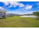Expansive back yard with a lush green lawn that leads to a tranquil pond, bordered by neighboring homes at 311 Beachgrass Ln, Summerville, SC 29486