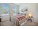 Cozy bedroom featuring carpet, a plaid comforter, two large windows and a decorative ocean-themed art piece at 311 Beachgrass Ln, Summerville, SC 29486
