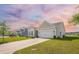 A well-maintained home with a two-car garage, complemented by lush greenery and a long driveway at 311 Beachgrass Ln, Summerville, SC 29486