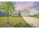 Charming single-story home featuring a well-manicured lawn and a two-car garage, complemented by mature landscaping at 311 Beachgrass Ln, Summerville, SC 29486
