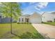 Charming single-story home featuring a well-manicured lawn and a two-car garage, complemented by mature landscaping at 311 Beachgrass Ln, Summerville, SC 29486