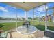 Relaxing screened porch offering peaceful views of a lush green yard and a serene pond, furnished with comfortable seating at 311 Beachgrass Ln, Summerville, SC 29486