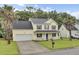 Charming two-story home featuring a welcoming front porch, two-car garage, and lush green lawn at 327 Eagle Ridge Rd, Summerville, SC 29485