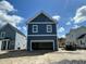 Exterior view of a detached two-car garage featuring blue siding, white trim, and an open entryway at 333 Trailmore Ln, Summerville, SC 29486