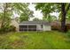 Home's back exterior features a screened porch and well-maintained lawn surrounded by mature trees at 40 Elmwood Pl, Goose Creek, SC 29445