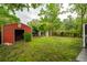 View of the backyard featuring a storage shed on a grassy lot with mature trees at 40 Elmwood Pl, Goose Creek, SC 29445