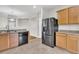 Open kitchen featuring wood cabinets, a stainless steel refrigerator, and a view to the dining area at 423 Watershed Dr, Goose Creek, SC 29445