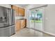 Modern kitchen featuring stainless steel refrigerator, wood cabinets, and sliding door access to the patio at 423 Watershed Dr, Goose Creek, SC 29445