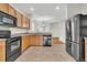 Stylish kitchen featuring wood cabinets, sleek black appliances, and an open view to the dining area at 423 Watershed Dr, Goose Creek, SC 29445