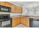 Well-lit kitchen featuring wood cabinets, ample counter space, and modern black appliances at 423 Watershed Dr, Goose Creek, SC 29445