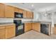 Well-equipped kitchen featuring wood cabinets, black appliances, and a seamless flow to the dining area at 423 Watershed Dr, Goose Creek, SC 29445