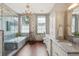 Elegant bathroom featuring marble countertops, a chandelier, and natural light from two windows at 43 Hasell St, Charleston, SC 29401