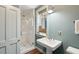Bright bathroom featuring a glass shower, a pedestal sink and a stylish window that provides natural light at 43 Hasell St, Charleston, SC 29401