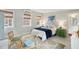 Bright, airy bedroom boasts a stylish bed, vintage wicker furniture, and charming decor at 43 Hasell St, Charleston, SC 29401
