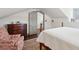 Bright bedroom with a wooden bed frame, patterned armchair, and doorway with stylish details in a well-lit space at 43 Hasell St, Charleston, SC 29401