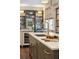 Kitchen island with white marble countertop, brass faucet, and built-in shelving and bookcase at 43 Hasell St, Charleston, SC 29401