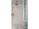 Modern shower with white tile, a glass door, mosaic floor, and sleek fixtures and shower head at 43 Hasell St, Charleston, SC 29401