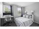 Bedroom features neutral walls, two windows, a bed, and a modern desk for work or study at 4621 Holmes Ave, North Charleston, SC 29405