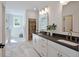 Modern bathroom with double sinks, stone countertops, marble flooring, and a large walk-in closet at 477 Yellow House Pl, Charleston, SC 29492
