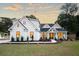 Beautiful two-story home featuring a pristine green lawn and attractive landscaping at sunset at 477 Yellow House Pl, Charleston, SC 29492
