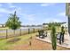 Serene backyard with a black fence, established trees, lake views, and a patio at 511 Ocean Mist Way, Summerville, SC 29486